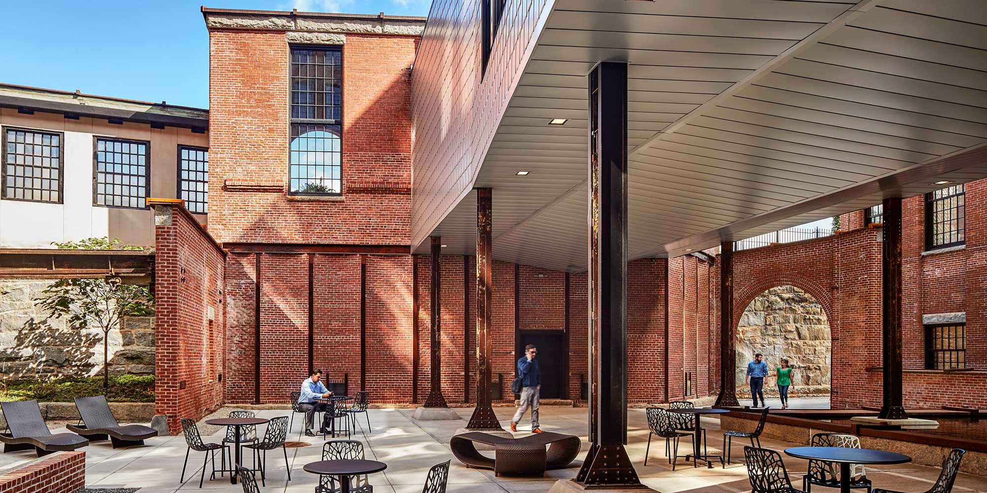 Vast open-air courtyard with deck seating, exposed brick and iron
